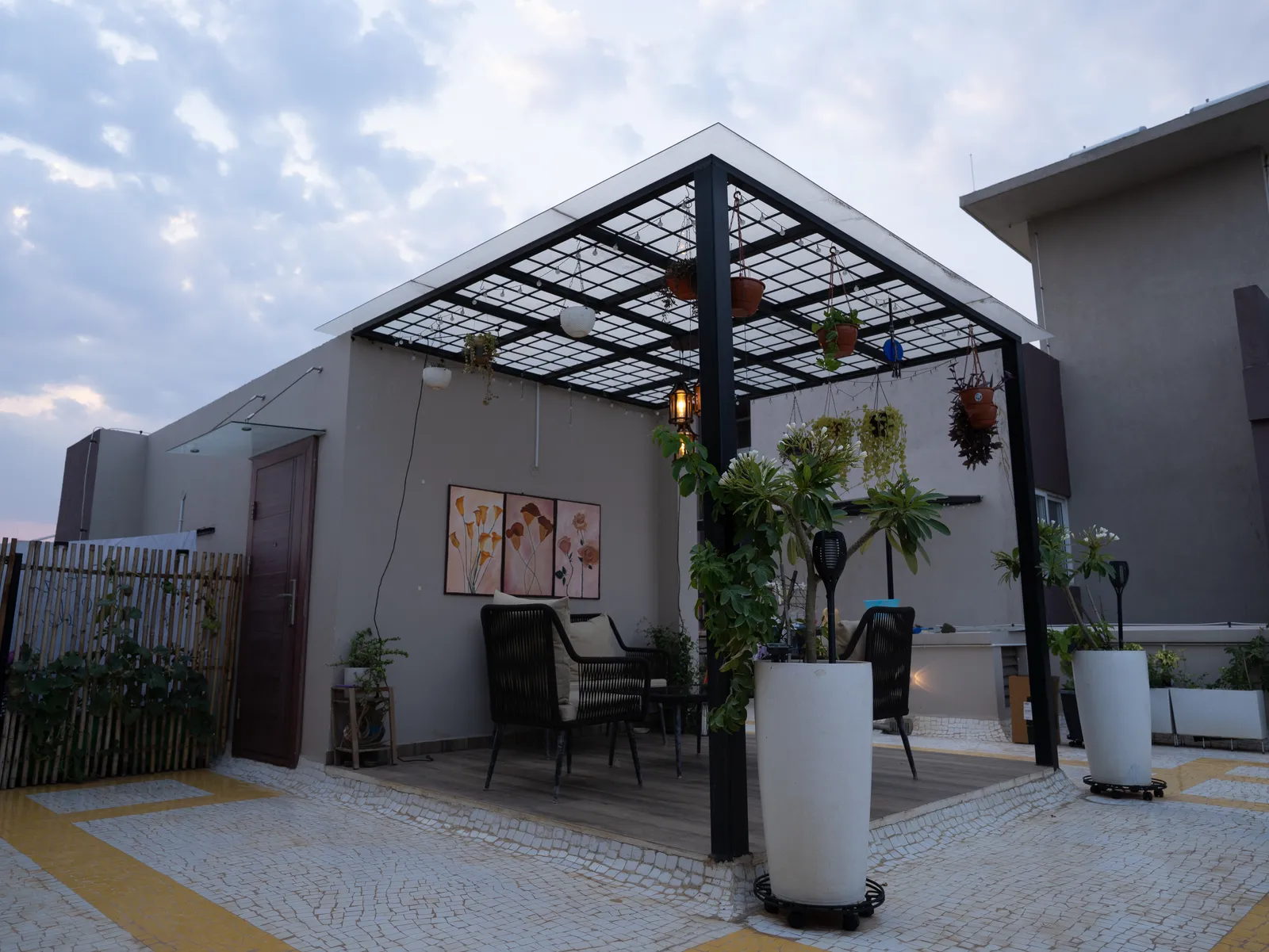 Rooftop terrace with steel pergola and outdoor seating — Amlan's Residence